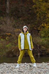 Portrait of young woman standing on rock