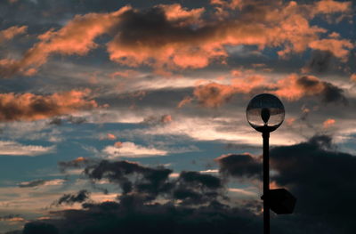 Silhouette street light against sky at sunset