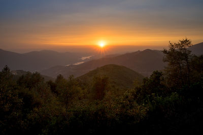 Scenic view of mountains against orange sky