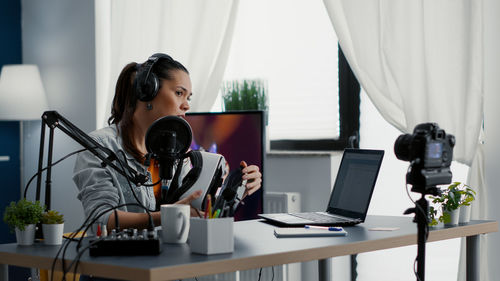 Side view of man using laptop on table