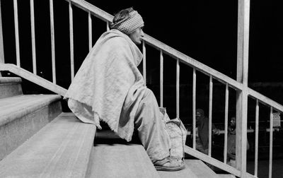 Side view of man sitting on stairs