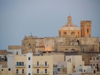 Buildings in city against clear sky