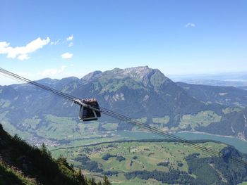 Overhead cable car with mountain range in the background