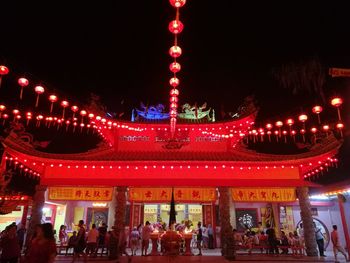 Low angle view of illuminated lanterns against sky at night