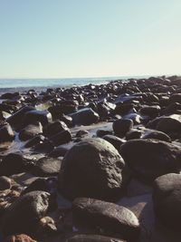 Rocks on beach against clear sky