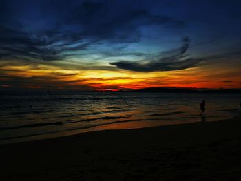 Scenic view of sea against dramatic sky during sunset