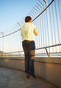 Rear view of woman standing on footbridge