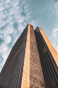 Low angle view of modern building against cloudy sky