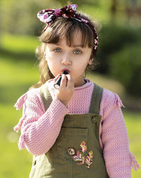 Portrait of cute girl holding purple flower