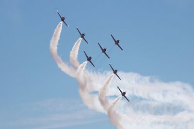 Low angle view of airshow against sky