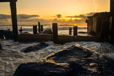 Destroyed sea defence against  sunrise