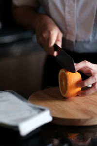 Midsection of person preparing food on cutting board