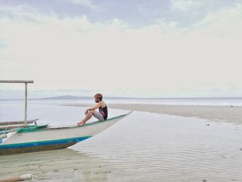 Boy on beach against sky