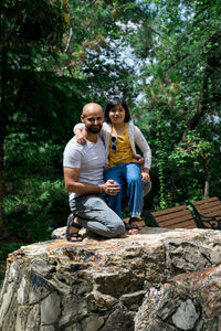 Side view of woman sitting on rock