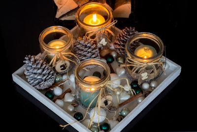High angle view of illuminated candles in tray