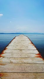 Pier over sea against blue sky