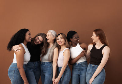 Friends standing against orange background