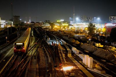 High angle view of railroad tracks amidst buildings in city at night
