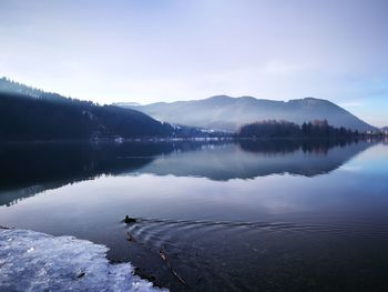 Scenic view of lake against sky during winter