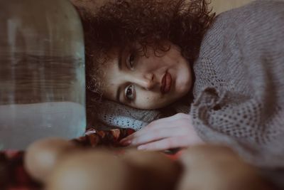 Portrait of woman lying on bed