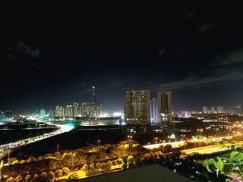 Illuminated buildings in city against sky at night