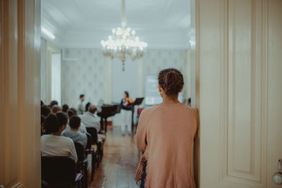 Rear view of woman standing on doorway at concert