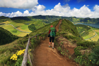 Rear view of woman with backpack walking on mountain