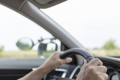 Midsection of man seen through car windshield