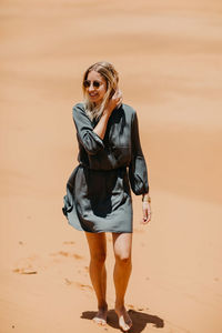 Woman walking on desert in sunny day