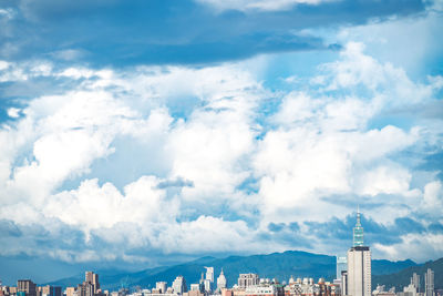 Aerial view of buildings against cloudy sky