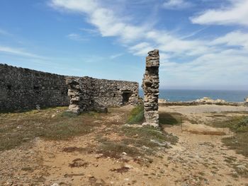 Old ruins by sea against sky