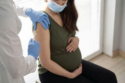 Midsection of doctor giving injection to patient