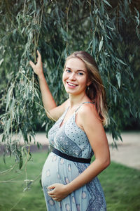 Portrait of smiling young woman standing on land