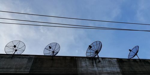 Low angle view of telephone pole against blue sky