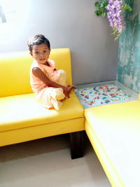 Portrait of boy sitting on sofa at home