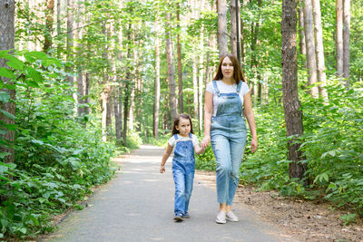 Full length of women walking in forest