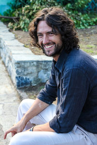 Portrait of smiling young man sitting outdoors