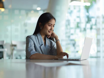 Young businesswoman working on laptop at office