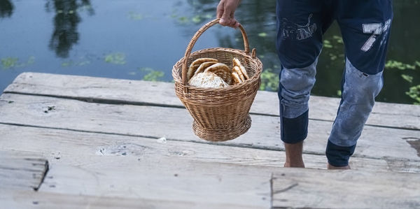 Low section of man standing on wicker basket