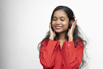 Portrait of a smiling young woman against white background