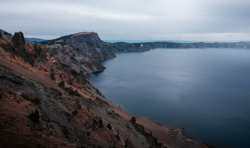 Scenic view of sea and mountains against sky