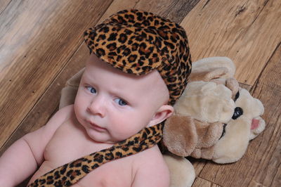 Close-up of baby boy wearing costume on hardwood floor