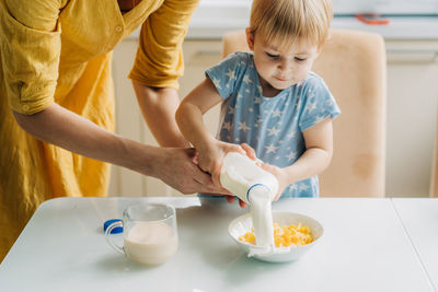 High angle view of mother carrying daughter on table