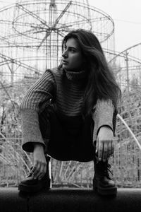 Full length of young woman sitting outdoors