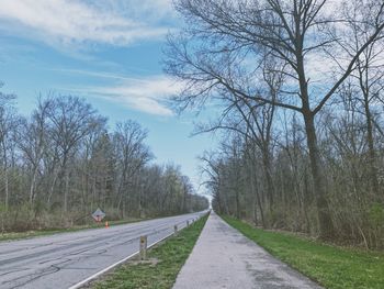 Road amidst trees against sky