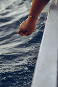 Close-up of hand over sea