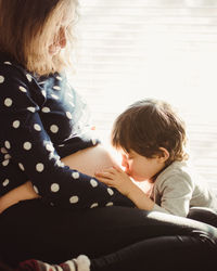 Rear view of mother and son at home