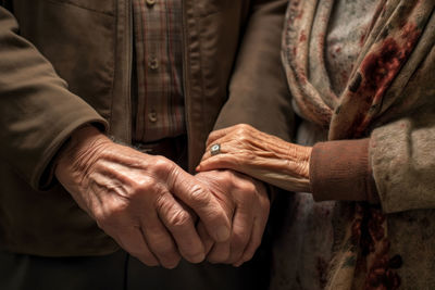 Midsection of couple holding hands