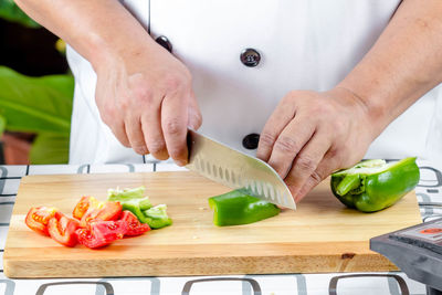 Cropped image of person preparing food on cutting board