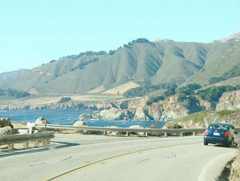 Cars on beach against clear sky